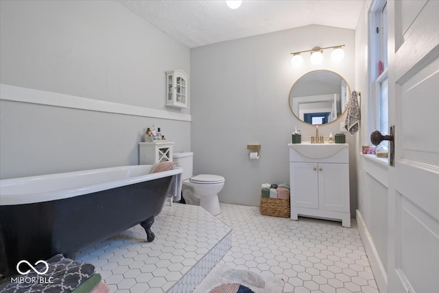 bathroom featuring tile patterned flooring, lofted ceiling, toilet, and vanity