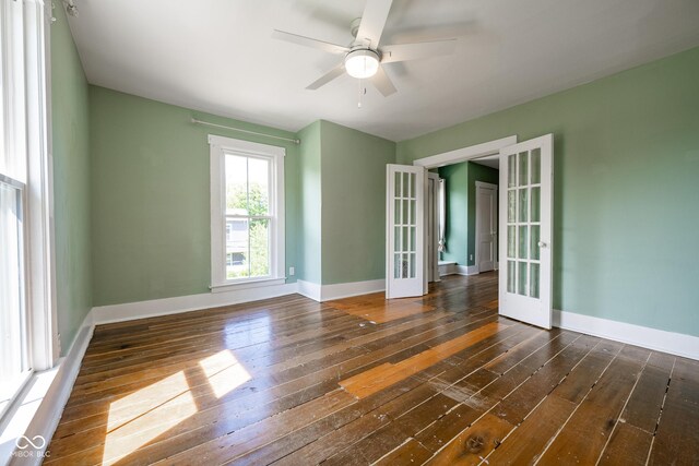 unfurnished room featuring dark wood-style floors, french doors, baseboards, and a ceiling fan