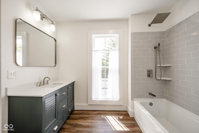 full bath featuring baseboards, vanity, shower / tub combination, and wood finished floors