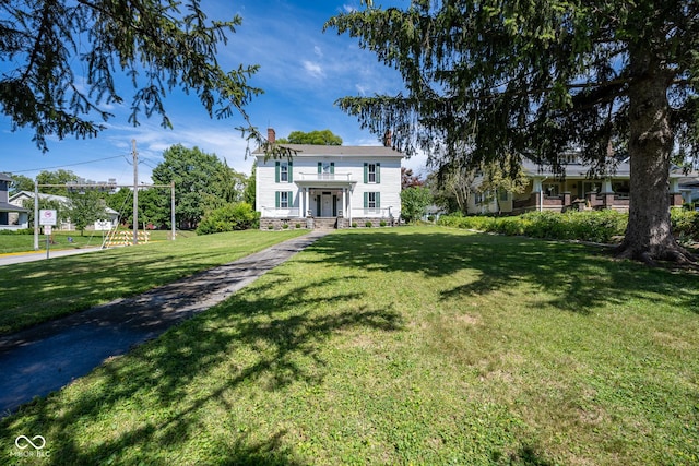 view of front of house featuring a chimney and a front lawn