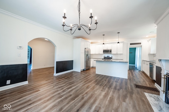 kitchen featuring white cabinets, open floor plan, hanging light fixtures, appliances with stainless steel finishes, and a center island