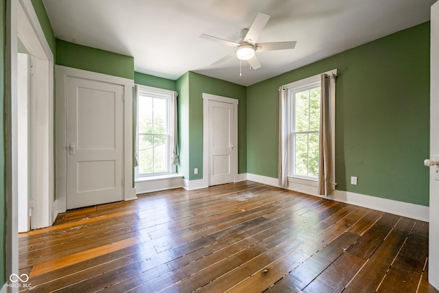 unfurnished bedroom featuring ceiling fan, dark wood finished floors, and baseboards