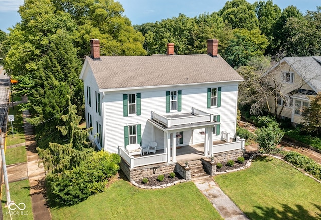 view of front of house featuring covered porch and a front lawn