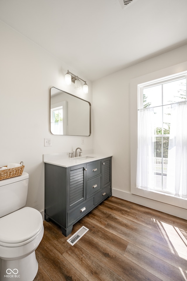 bathroom featuring hardwood / wood-style flooring, toilet, and vanity