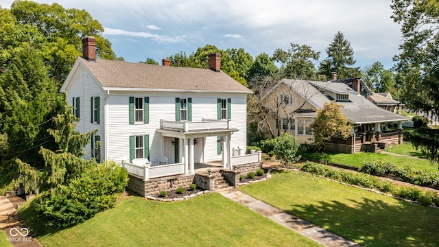 view of front of house with a balcony and a front yard