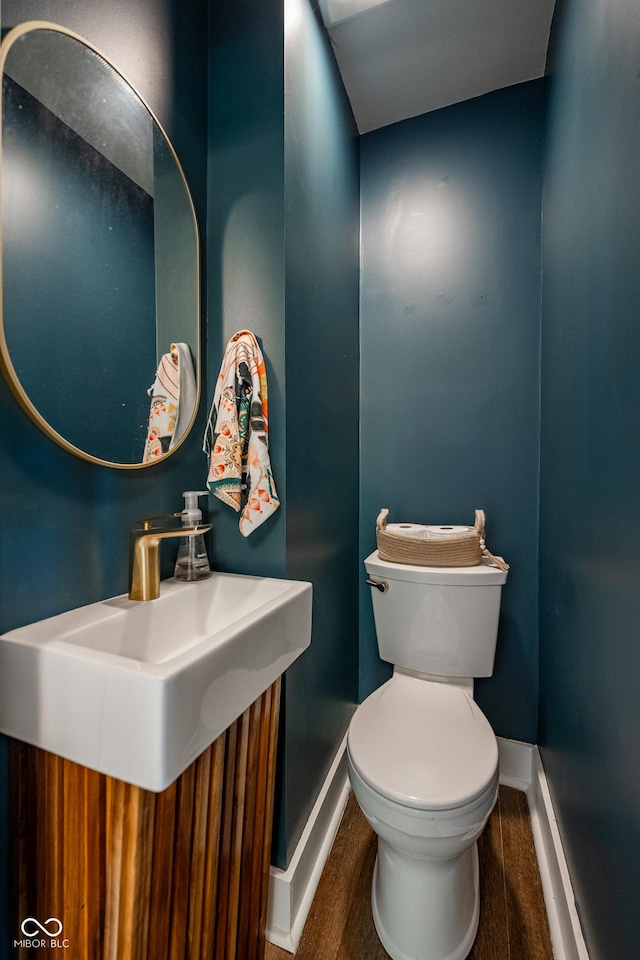 bathroom featuring baseboards, a sink, and toilet