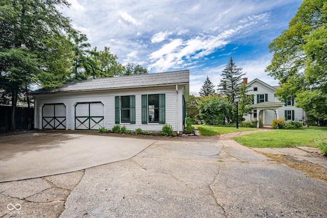 view of front of property with a garage, concrete driveway, and a front yard