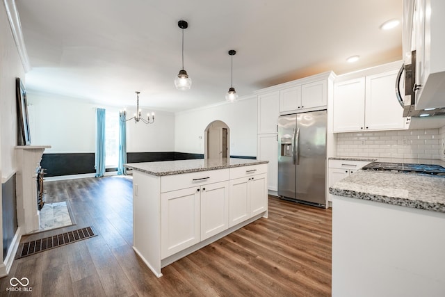 kitchen with white cabinetry, stainless steel fridge with ice dispenser, open floor plan, a center island, and decorative light fixtures