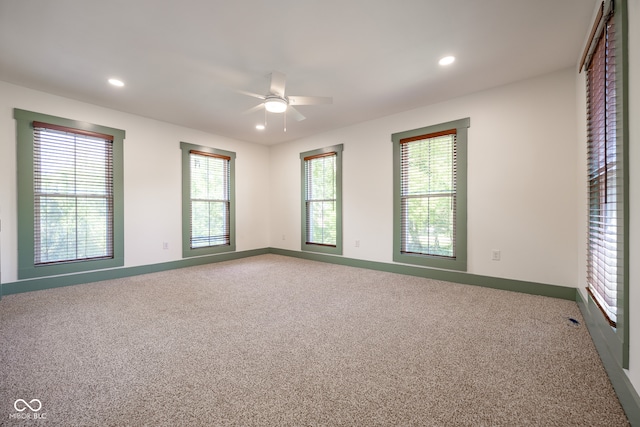 spare room featuring plenty of natural light, ceiling fan, and carpet flooring