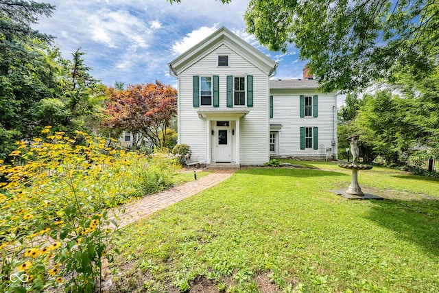 view of front of property with a chimney and a front yard