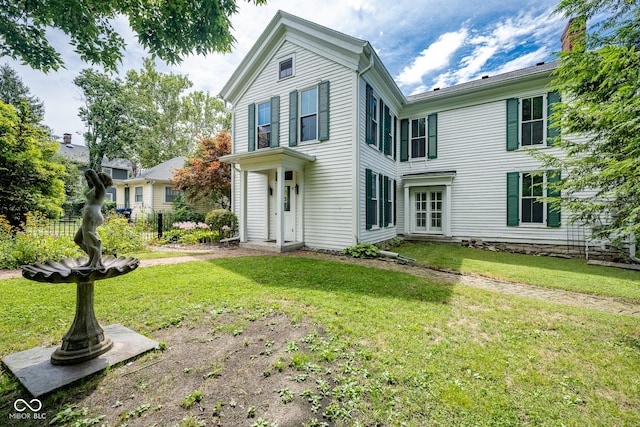 traditional-style home with a front yard and fence