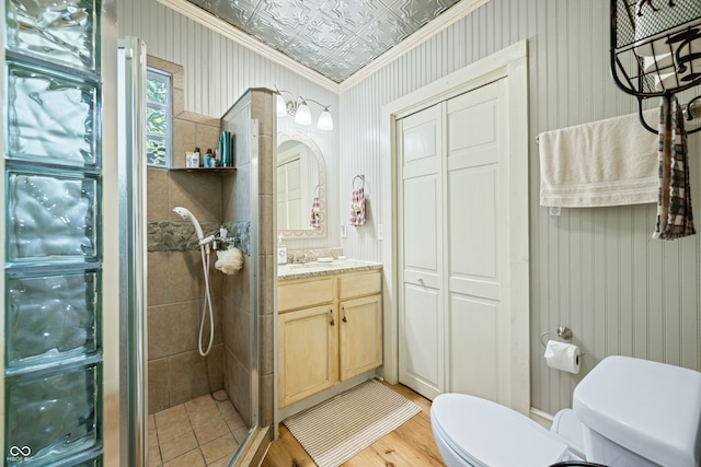 bathroom featuring vanity, walk in shower, wood-type flooring, ornamental molding, and toilet