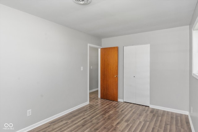 unfurnished bedroom featuring hardwood / wood-style flooring and a closet