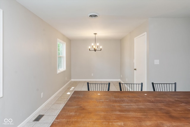 unfurnished dining area featuring light tile patterned flooring and an inviting chandelier