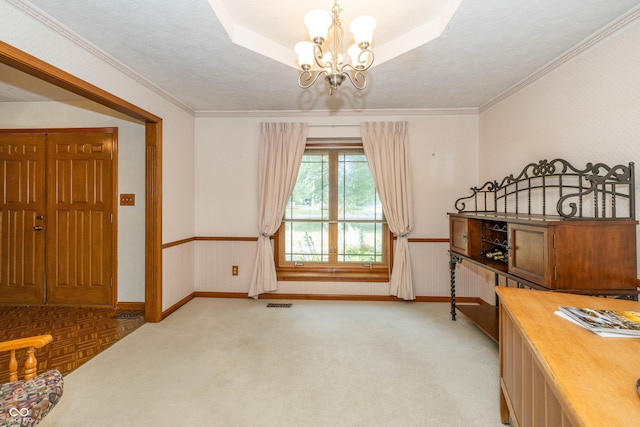 carpeted bedroom with crown molding, a chandelier, and a raised ceiling