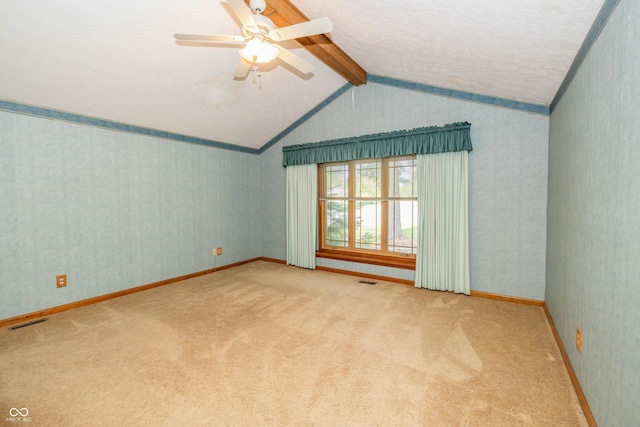 carpeted spare room with vaulted ceiling with beams and ceiling fan