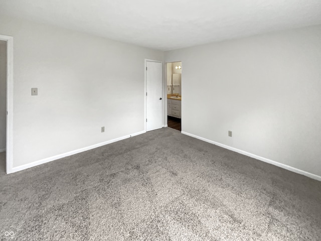 interior space featuring dark colored carpet and ensuite bath