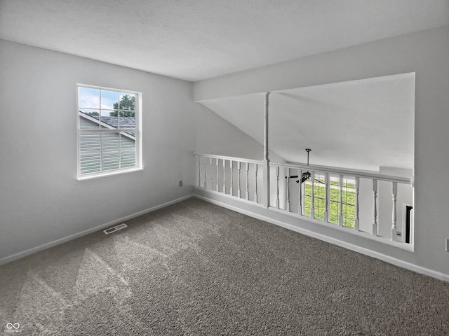 carpeted spare room with vaulted ceiling and plenty of natural light