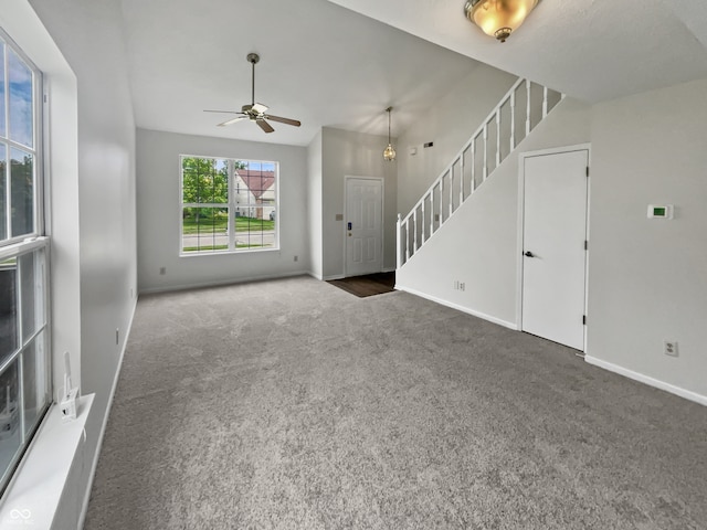 unfurnished living room featuring ceiling fan and carpet flooring