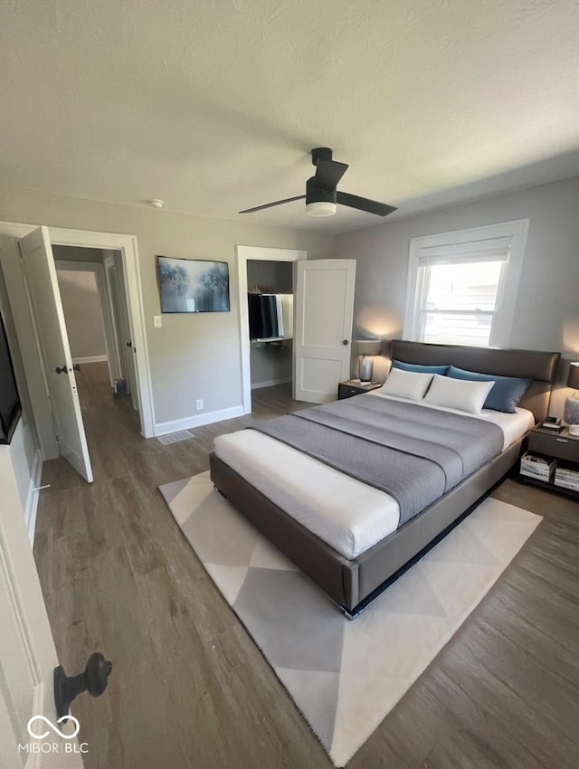 bedroom featuring hardwood / wood-style flooring, a textured ceiling, and ceiling fan