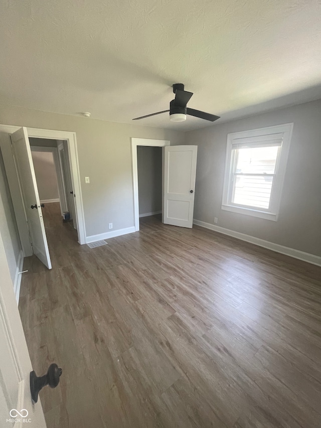 unfurnished bedroom featuring hardwood / wood-style floors and ceiling fan