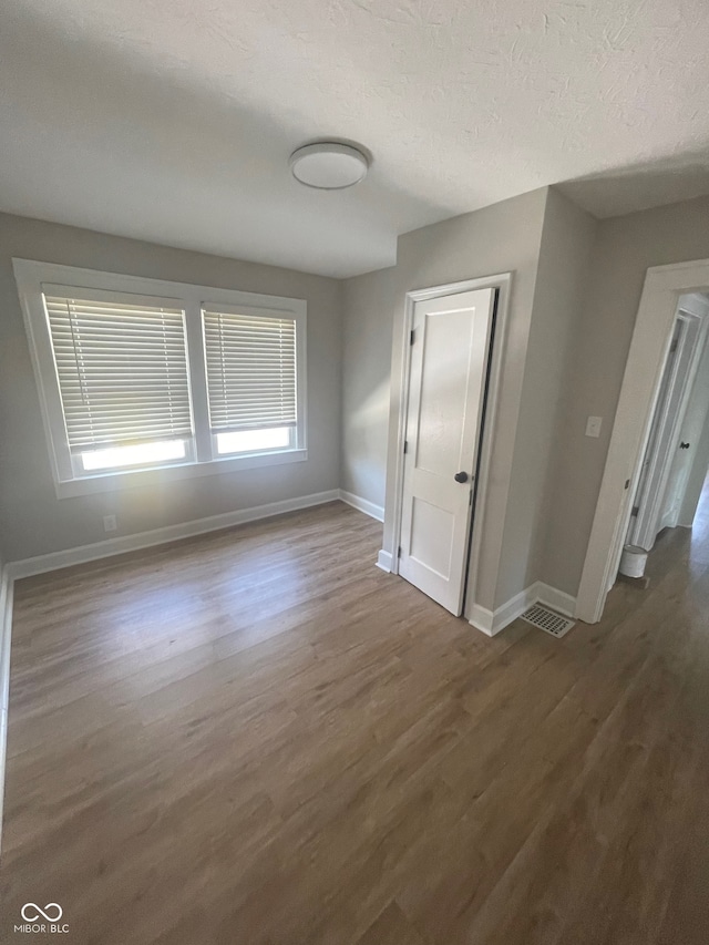 interior space with hardwood / wood-style flooring and a textured ceiling