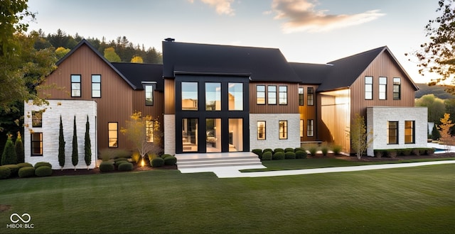 back house at dusk featuring a yard