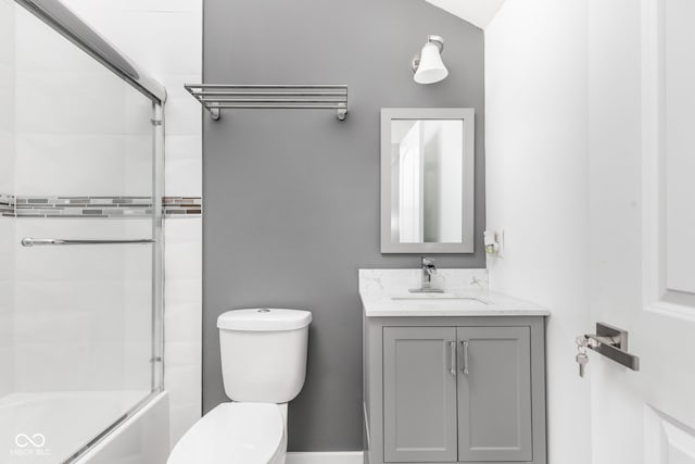 full bathroom featuring shower / bath combination with glass door, vanity, and toilet