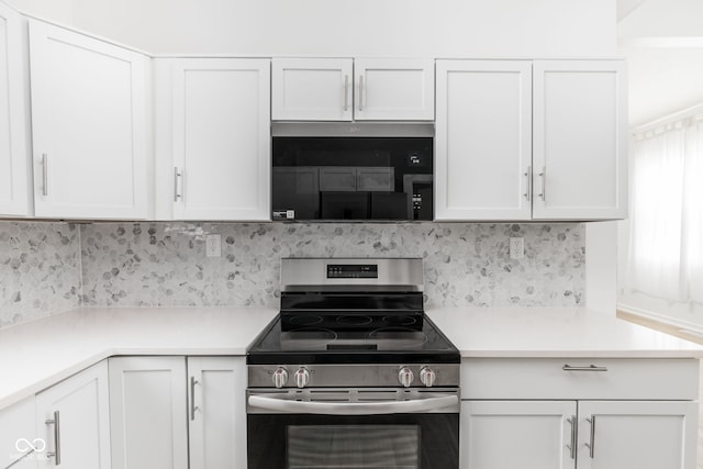 kitchen featuring white cabinets, decorative backsplash, and stainless steel range oven