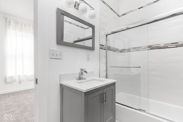 bathroom featuring combined bath / shower with glass door and vanity