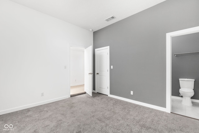 unfurnished bedroom with carpet floors and connected bathroom