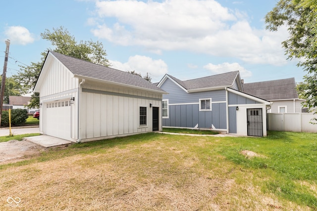 rear view of house with a lawn and a garage