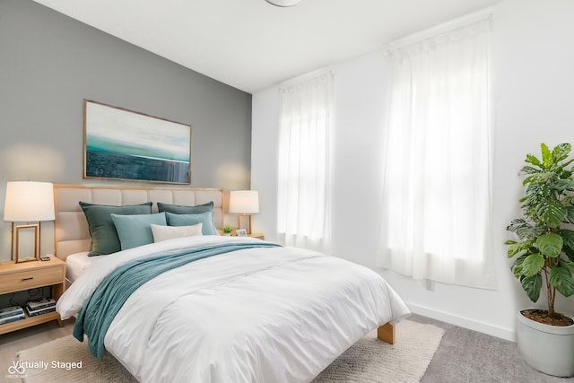 bedroom with multiple windows and light colored carpet