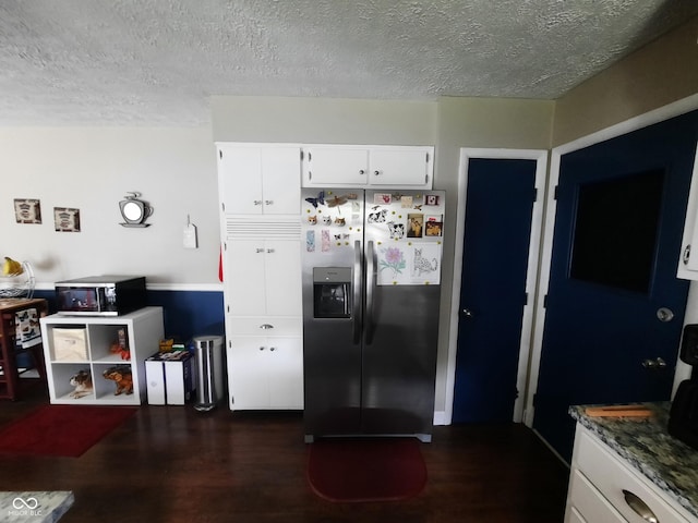 kitchen featuring dark wood-type flooring, a textured ceiling, white cabinets, stainless steel fridge with ice dispenser, and dark stone counters