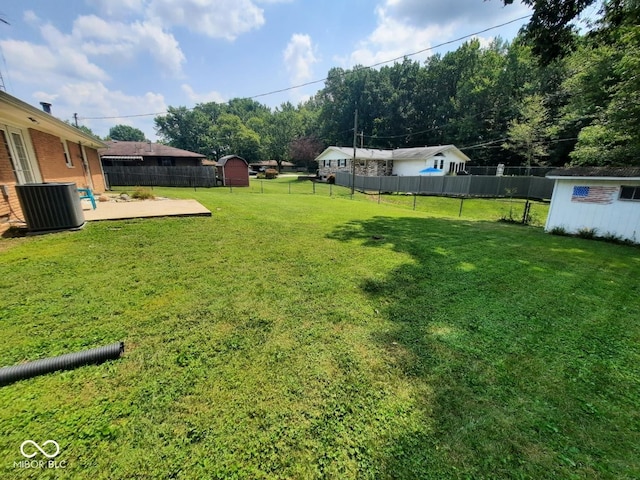 view of yard with central AC unit and a shed