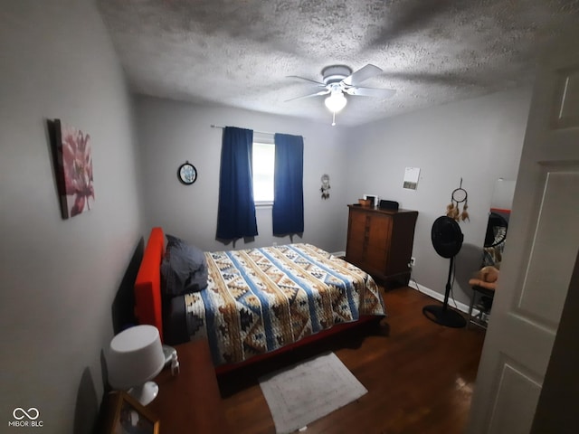 bedroom with dark hardwood / wood-style flooring, ceiling fan, and a textured ceiling