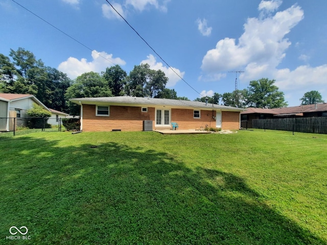 back of house featuring a lawn and a patio