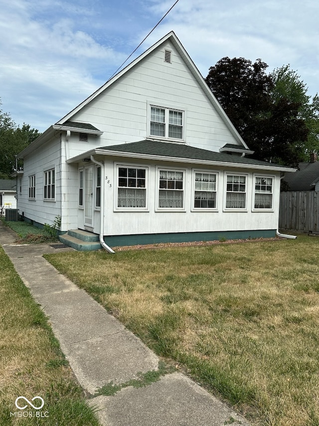 view of front facade featuring central air condition unit and a front yard