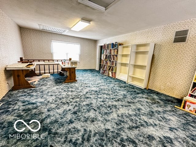 misc room featuring a textured ceiling and carpet