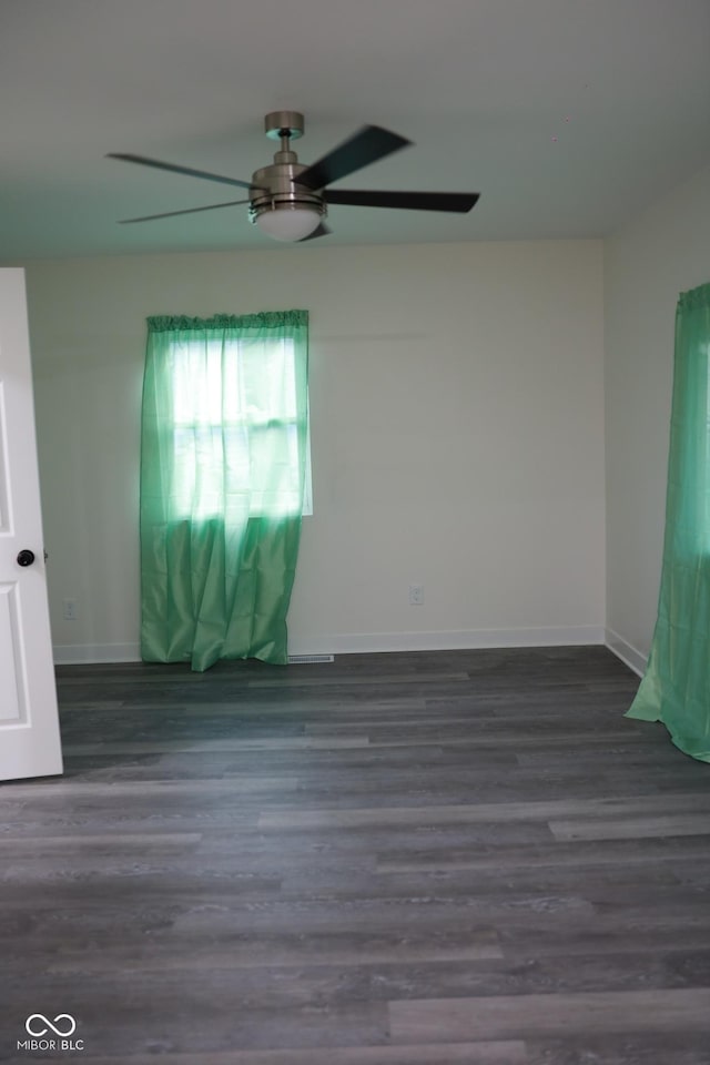 unfurnished room with dark hardwood / wood-style floors and ceiling fan