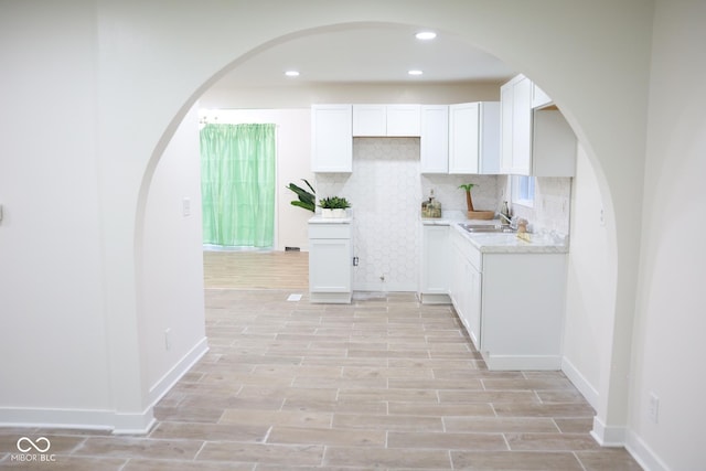 kitchen featuring tasteful backsplash, sink, and white cabinets