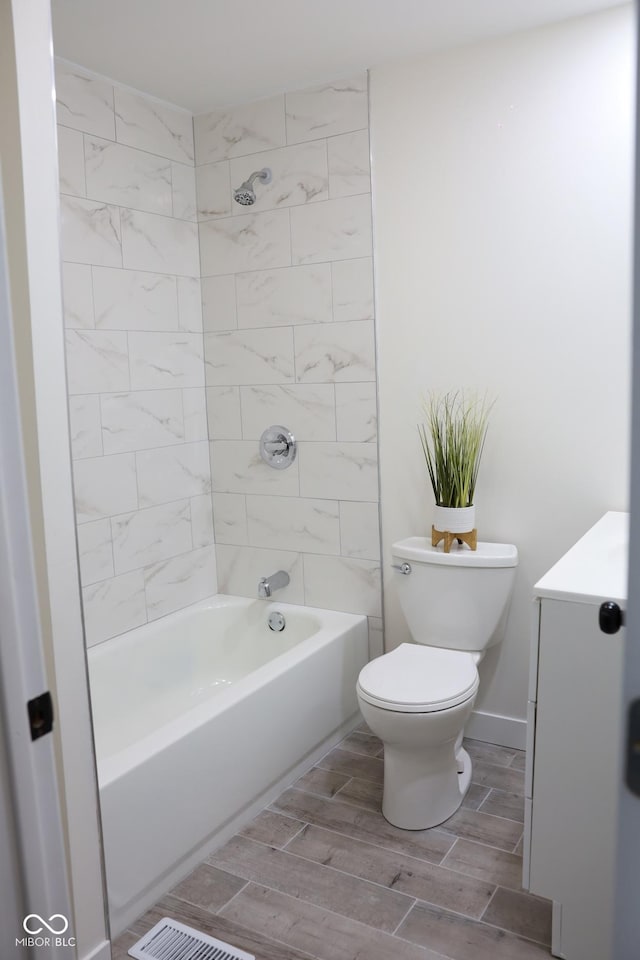 bathroom featuring tiled shower / bath and toilet