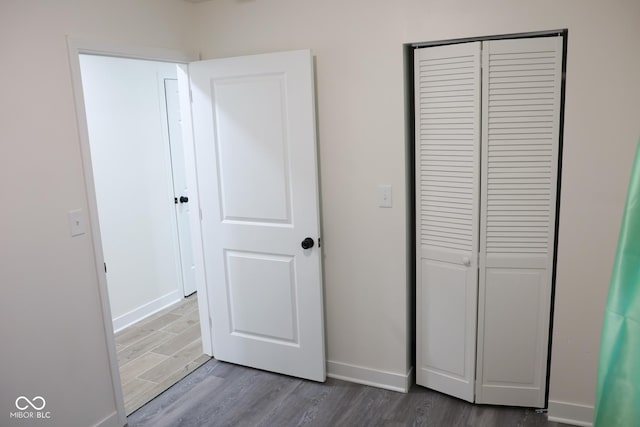 unfurnished bedroom featuring dark hardwood / wood-style flooring and a closet