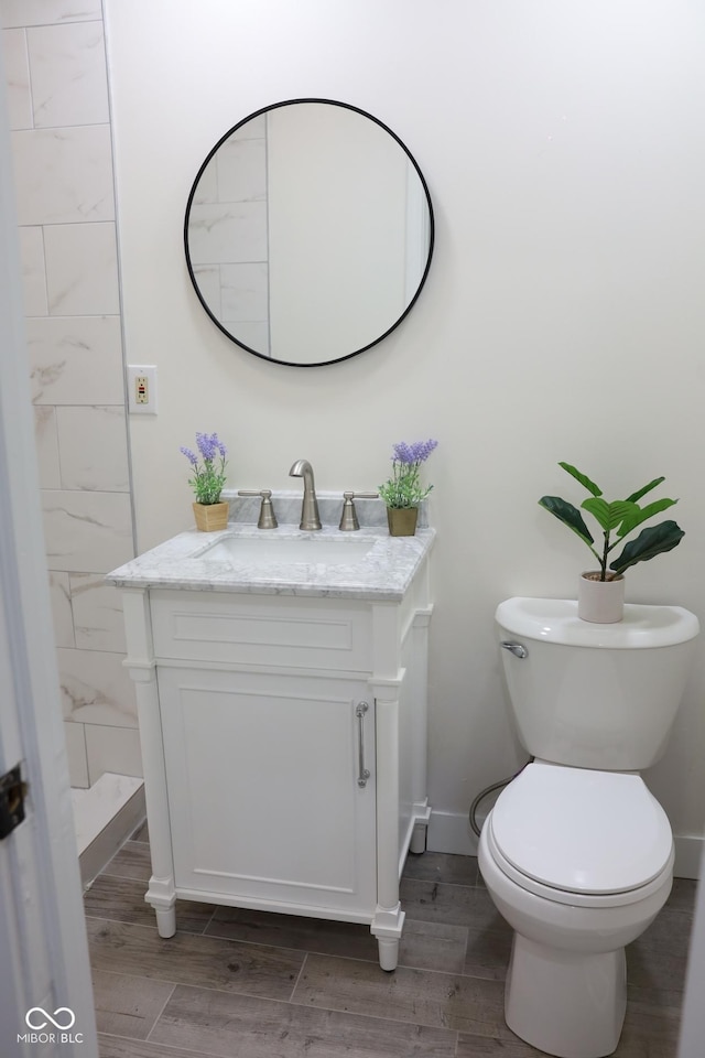 bathroom featuring vanity, toilet, and hardwood / wood-style floors