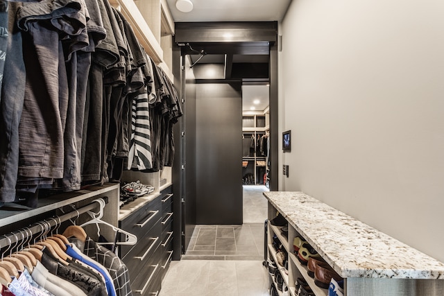 walk in closet with light tile patterned floors