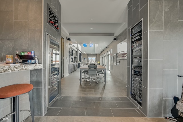 corridor with tile patterned floors and tile walls