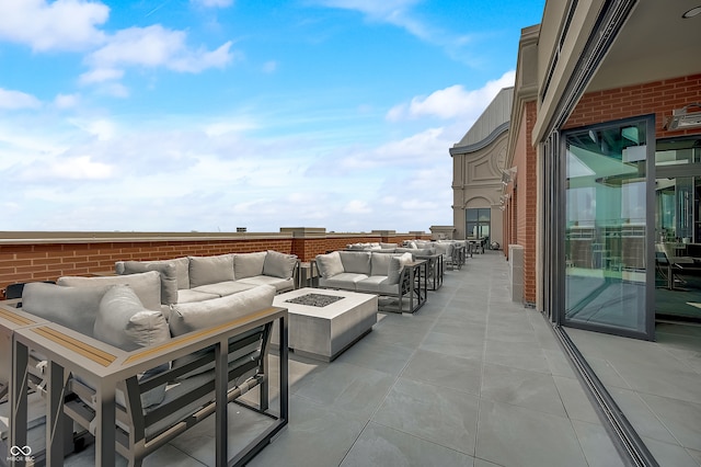 view of patio with an outdoor living space with a fire pit