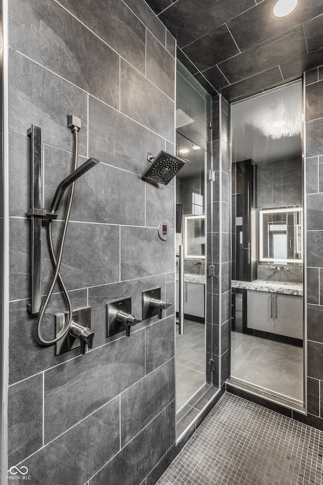 bathroom with tiled shower and vanity