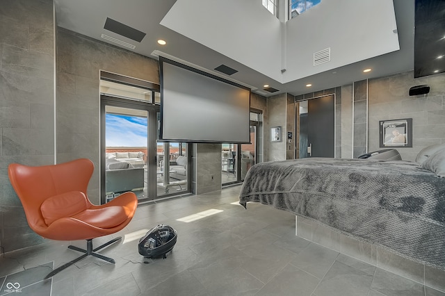 tiled bedroom with tile walls, multiple windows, and a high ceiling