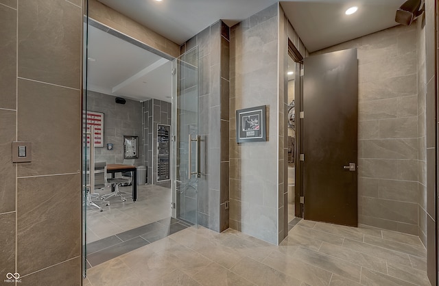 bathroom with tile patterned floors and tile walls